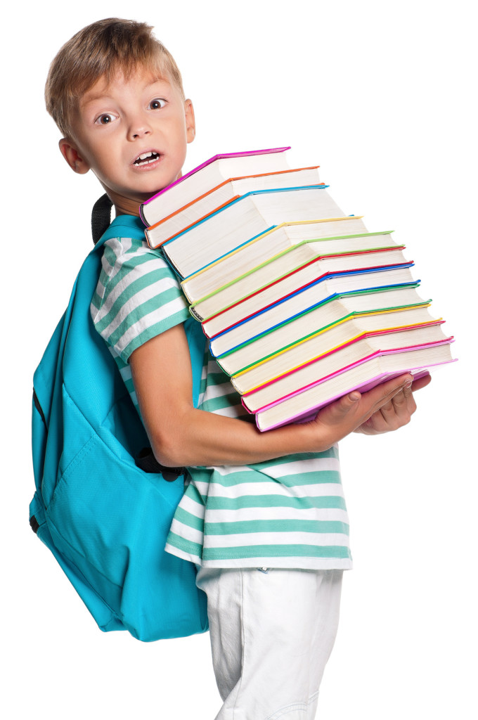 Happy little boy with books isolated on white background